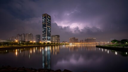 Dramatic night cityscape with a towering skyscraper lightning illuminating the stormy sky and reflections shimmering on the water