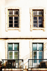 Fototapeta premium Typical old buildings in Lisbon's lower town, with their windows with balconies, lanterns, and decorative tiles. Lisbon, Portugal, 2023