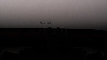 Close up of a vintage typewriter imprinting the words the end on white paper, evoking finality, storytelling, nostalgia, and the closing moment of a creative journey