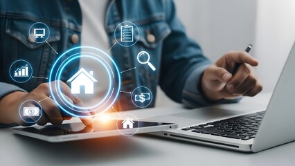 Real estate technology person using laptop and tablet with home and business icons displayed
