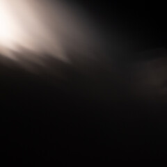Abstract Dark Black Background with a Soft, Diagonal Light Beam or Lens Flare in the Top Corner, Creating a Mysterious and Atmospheric Effect