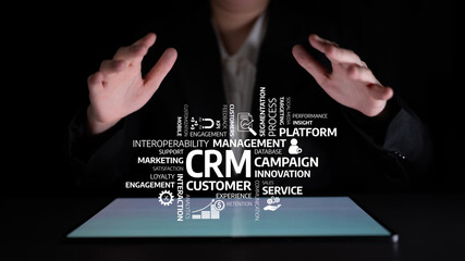A business professional interacts with a digital display that highlights key aspects of CRM technology, showcasing engagement and innovative strategies for customer management. Tessel