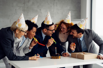 A group of business professionals celebrating a company anniversary in a modern office. Colleagues...