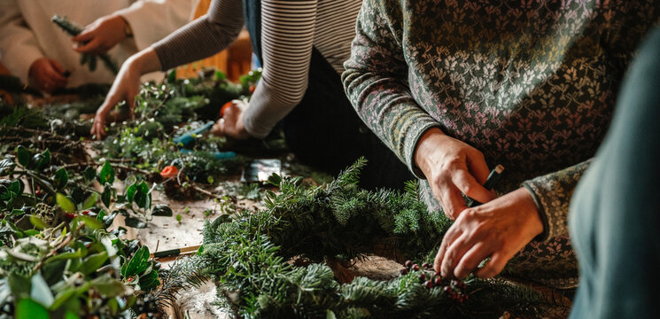 Gemeinsames Adventskranzbinden mit Tannenzweigen und Naturmaterialien