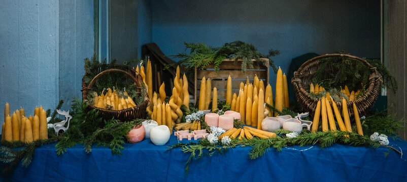 Handgemachte Bienenwachskerzen auf dekoriertem Marktstand