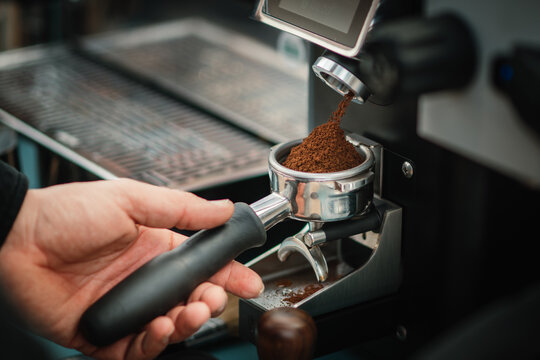 Frisch gemahlener Kaffee f&auml;llt in einen Siebtr&auml;ger
