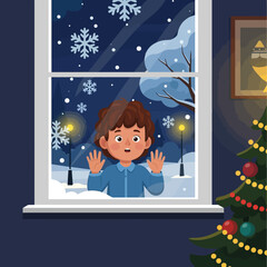 Excited boy looking at snowfall with Christmas tree in a cozy room