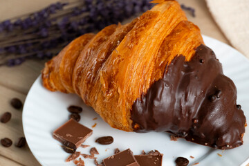 Chocolate-dipped croissant with coffee beans and lavender