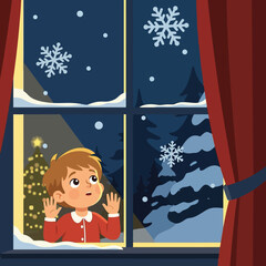 Excited child watches falling snow outside Christmas window at nighttime