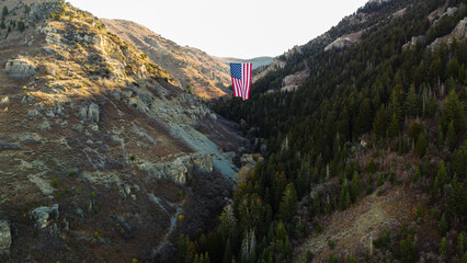 Naklejka premium Aerial Drone Views of The Major Large American Flag Hanging in Mountains of North Ogden Utah Veterans Day 
