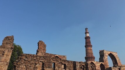 Architectural Heritage of Delhi: The Majestic Minaret, Surrounded by the Weathered Pillars and Fragmented Structures of the Old Mosque, Emphasizing the Scale and Grandeur of the Site.