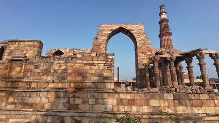 Architectural Heritage of Delhi: The Majestic Minaret, Surrounded by the Weathered Pillars and Fragmented Structures of the Old Mosque, Emphasizing the Scale and Grandeur of the Site.