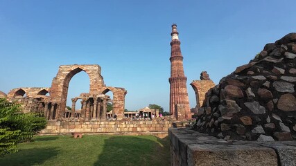 Architectural Heritage of Delhi: The Majestic Minaret, Surrounded by the Weathered Pillars and Fragmented Structures of the Old Mosque, Emphasizing the Scale and Grandeur of the Site.