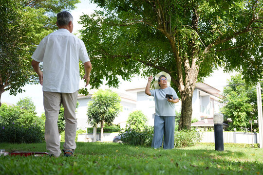 Senior couple enjoying outdoor activity and exploring garden together, Elderly couple spending time in backyard park, Active senior lifestyle with older adults walking and observing nature - Powered by Adobe