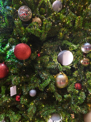 Joyful christmas pine tree set features hanging red bauble and silver ornament decoration. Festive holiday backdrop offers ample copyspace for greeting message evoking cheerful spirit