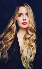 Fototapeta premium Beautiful young blonde woman with wavy hair and red lips, looking up, portraying beauty, elegance, and fashion