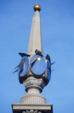 Seven Dials Sundial Pillar with pigeons roundabout in West End, City of London, England.