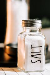 Salt shaker on kitchen counter with soft lighting and blurred background