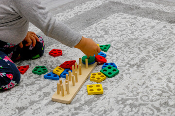 Little girl playing with a sorter on the floor at home