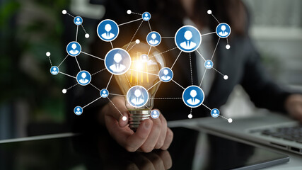 This image represents the concept of innovation and networking, showcasing a light bulb surrounded by people icons in a professional environment, symbolizing ideas and connections. Tessel