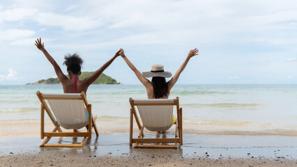 Two cheerful women smiling closely at the camera on a sunny beach, expressing genuine friendship, joy, and summer vacation vibes. A warm and happy moment perfect for travel, lifestyle, and holiday.