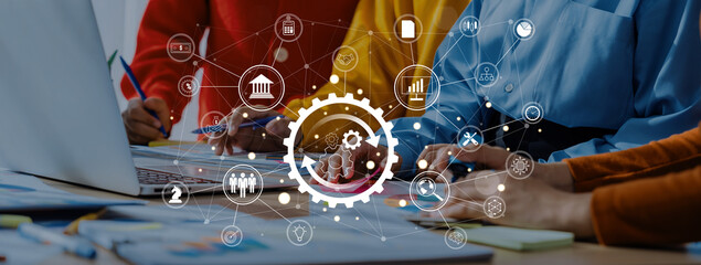 A diverse team collaborates on a laptop in a modern workspace, surrounded by digital interface elements showcasing innovation and business growth concepts. Trope