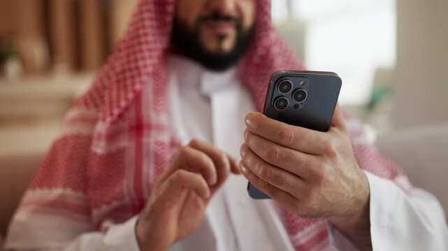 Pleased Arab man scrolling social media app on phone, enjoying mobile shopping