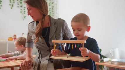 Care giver instruct child holding wooden abacus to return it, while other children remain engaged in classroom activities, capturing educational moment of early childhood learning - Powered by Adobe