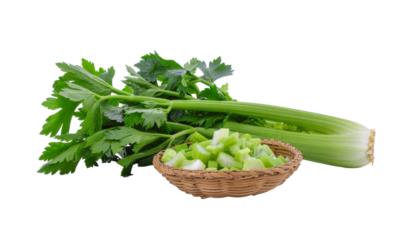 Celery stalk with green leaves and a small woven bowl of chopped celery pieces on a white background product shot isolated