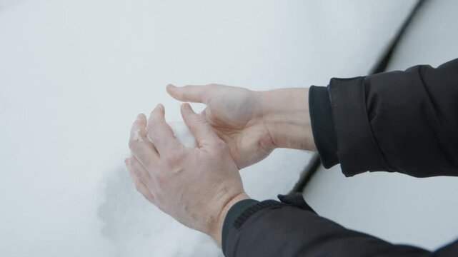 a man's hands are making a snowball in close-up, preparing for a throw. winter