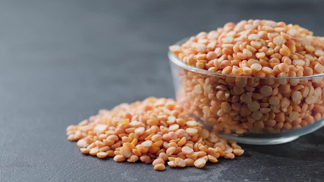  dried peas or yellow peas in a glass plate and scattered on a black marble background.