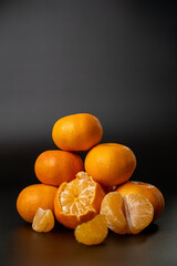 Fresh moist tangerines with water droplets on a dark background. Detailed citrus texture, vibrant orange color, and moist surface ideal for food, freshness, and healthy nutrition themes.