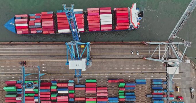 Large container ship docking at a bustling commercial port, heavy cranes moving shipping containers onto the vessel, symbolizing global logistics, import, and export