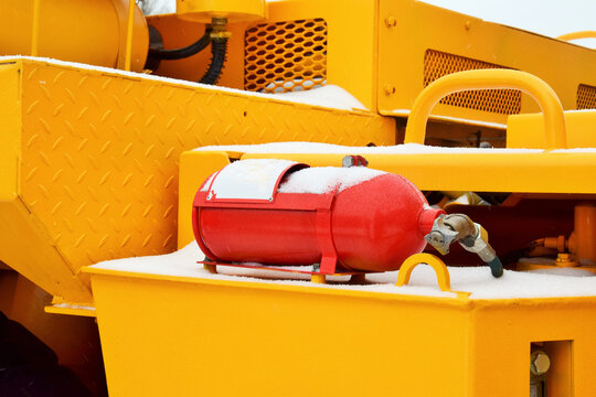 The fire suppression system of a quarry dump truck. The fire extinguisher is located on the fender of the truck.