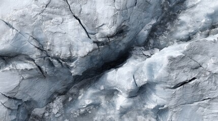 Fototapeta premium Detailed close-up of a rugged glacier surface showcasing unique textures and patterns of ice with cracks and crevices in varying shades of blue and gray