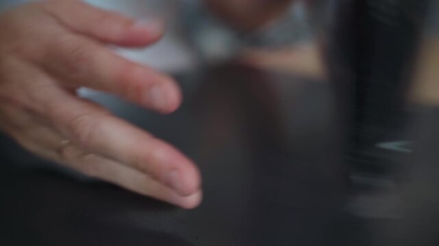 A closeup shot shows a hand pressing a plastic snap fastener to securely close a textile package, capturing the final stage of careful product packing for shipping