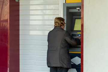 Senior woman using the ATM 