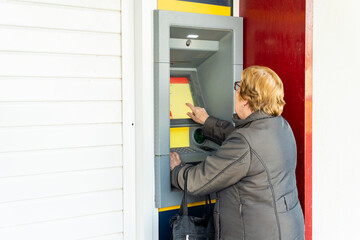 Senior woman using the ATM 