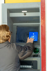 Senior woman using the ATM 