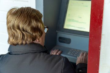 Senior woman using the ATM 