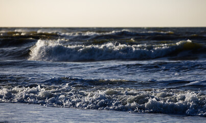 dark waves crashing on the beach on an evening