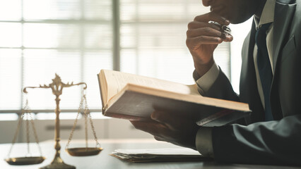 The justice worker is reading the legislation at his desk