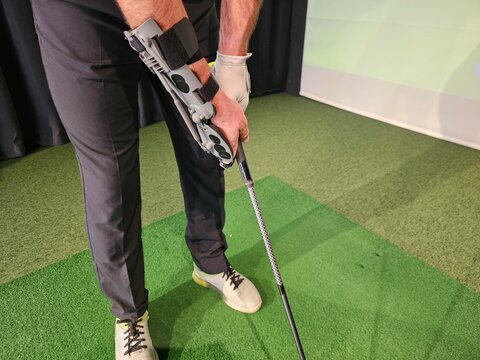 Innovative golf swing training aid used by golfer in indoor studio for skill improvement and practice concept