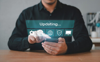 Person using a smartphone with a holographic interface displaying the word updating and various icons, symbolizing software updates and digital progress