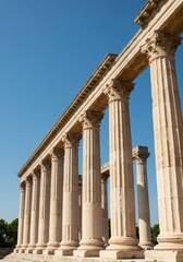 Fototapeta premium Majestic stone columns supporting an ancient structure against a clear blue sky, symbolizing enduring architecture of the empire and classical design, era, ruins, strength