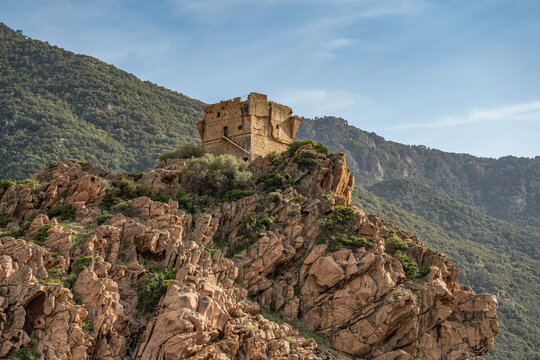 Aerial view town ruins Genoese tower of Porto Corsica France medieval watchtower Mediterranean Sea Calanches de Piana