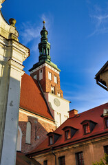 Zabytkowy kościół z czerwonymi dachami i wieżą. Lubiń - Klasztor Opactwa Benedyktynów. © Pol Badger