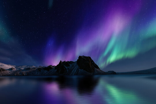 Aurora borealis, northern lights over a mountain lake in Iceland