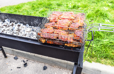Grilled meat on the grill is cooked on hot charcoals outdoors