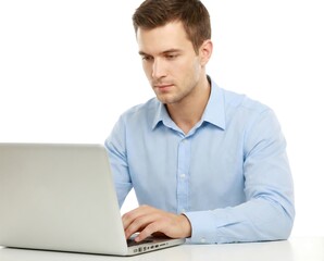 Professional young man in a blue shirt focused on typing on his laptop, isolated on a white backdrop.